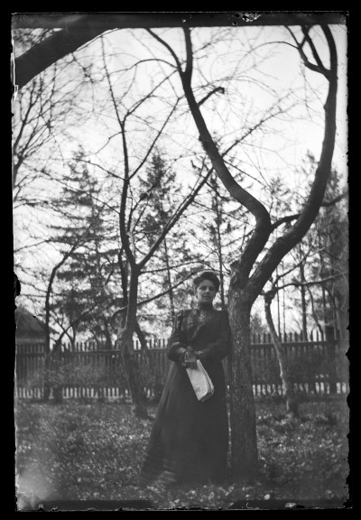 Portret kobiety w ogrodzie, trzymającej w ręku gazetę (prawdopodobnie "Słowo Polskie")