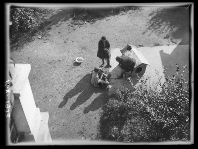 Widok z góry na podwórko domu Januszów przy ulicy Poniatowskiego w Rzeszowie. Po lewej - Irena Elgas, na budzie siedzi Krystyna Urban