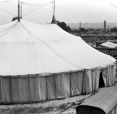 Cyrk Warszawa na placu zabaw przy górce obok Osiedlowych Plantów przy ul. Bolesława Krzywoustego. W tle komin kotłowni i bloki przy ul. Stanisława Staszica