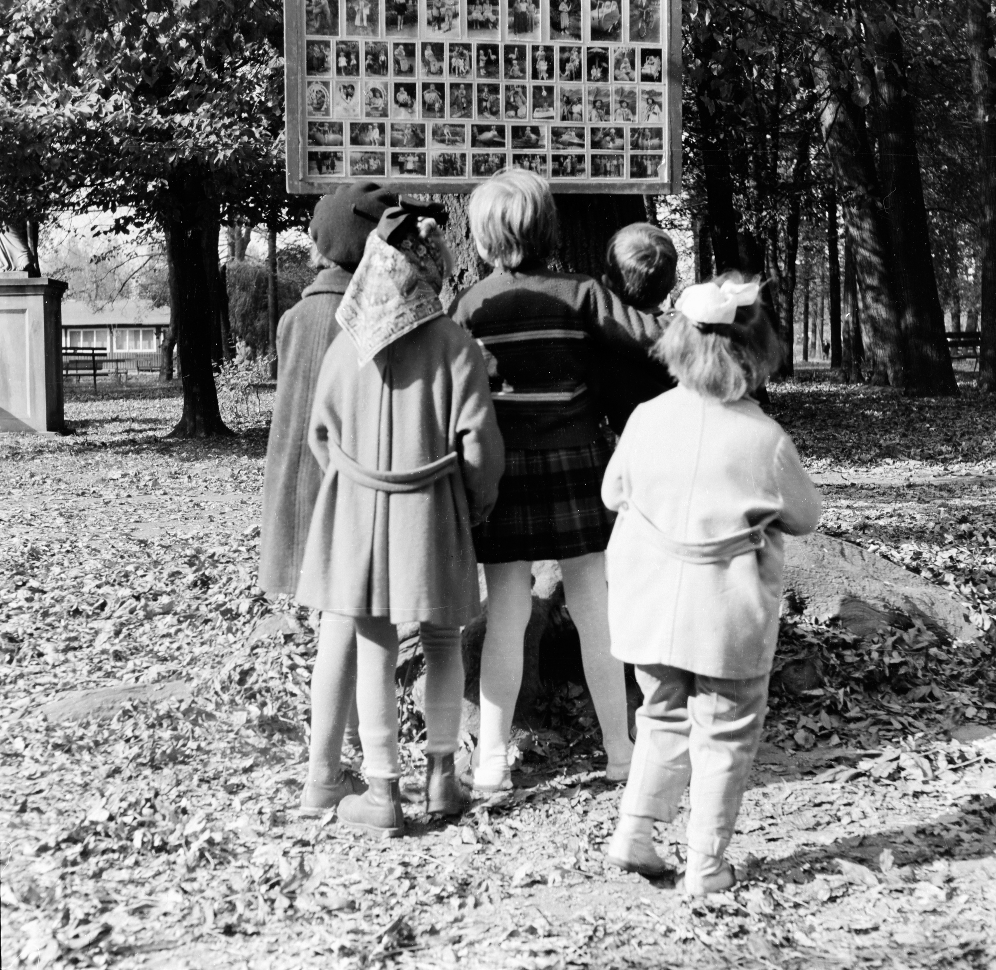 Dzieci przed tablicą ze zdjęciami w parku im. Ludwika Waryńskiego przy ul. gen. Jarosława Dąbrowskiego w Rzeszowie