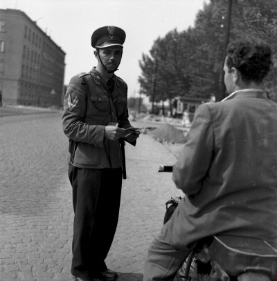 GFK-3-725 Milicjant przeprowadzający kontrolę na ul. gen. Jarosława Dąbrowskiego w Rzeszowie. Po lewej fragment Hotelu Iskra GFK-3-725.jpg
