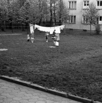 Kobieta z dziećmi i suszące się pranie na podwórku przed blokiem przy ul. Żwirki i Wigury w Rzeszowie