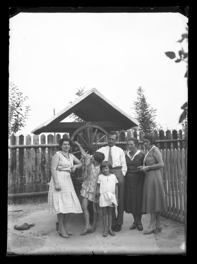 Helena Janusz (z prawej) z siostrą Marią Urban i siostrzenicą Krystyną Urban (stoja po lewej) oraz rodziną w ogrodzie przed studnią