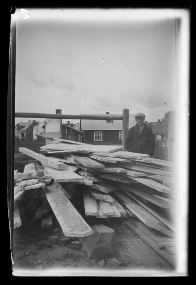 Mężczyzna przy stercie desek, prawdopodobnie w okolicach ul. Jagiellońskiej w Rzeszowie