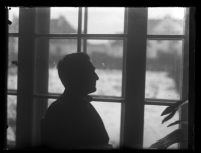 Mężczyzna siedzący przy oknie prawdopodobnie w słuzbowej willi Augustyna Urbana na warszawskim Żoliborzu