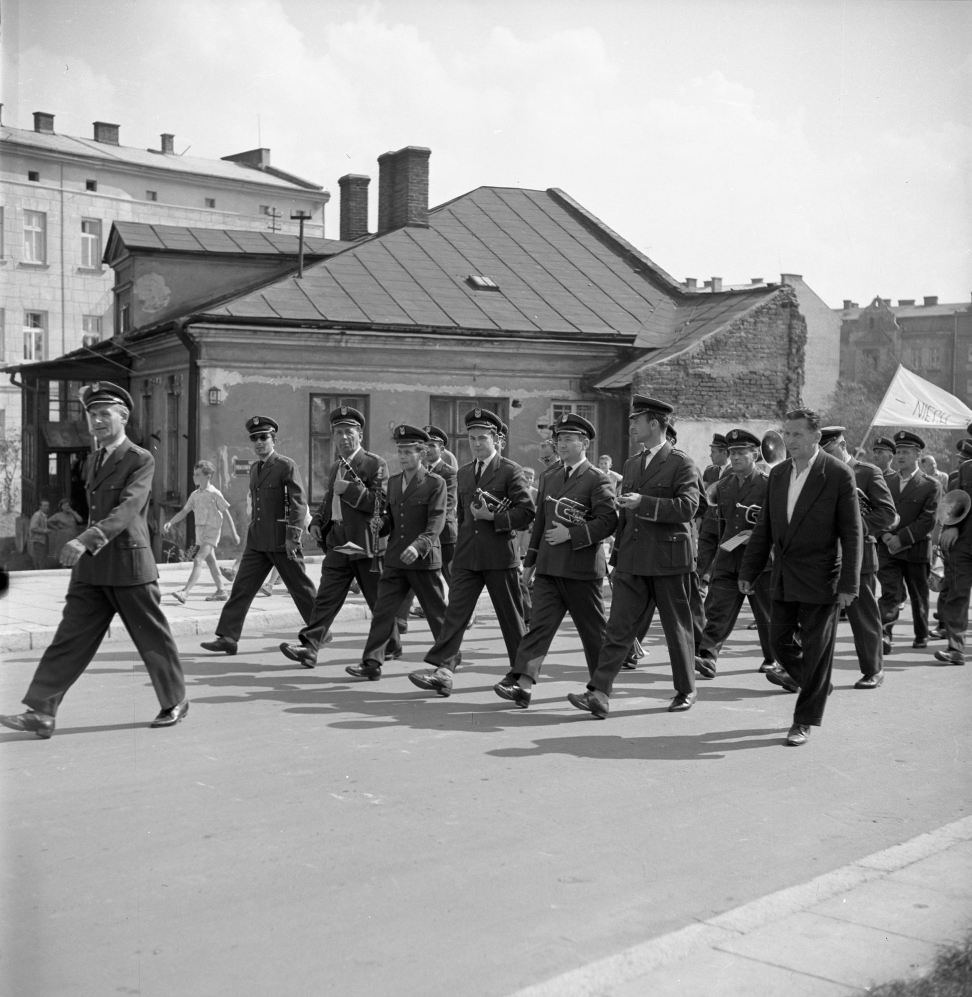 Orkiestra dęta Zakładowego Domu Kultury WSK PZL Rzeszów w pochodzie pierwszomajowym na ul. Juliusza Słowackiegow Rzeszowie. Po lewej koncertmistrz Józef Homik. W tle ul. Grodzisko z charakterystyczną kamienicą nr 3